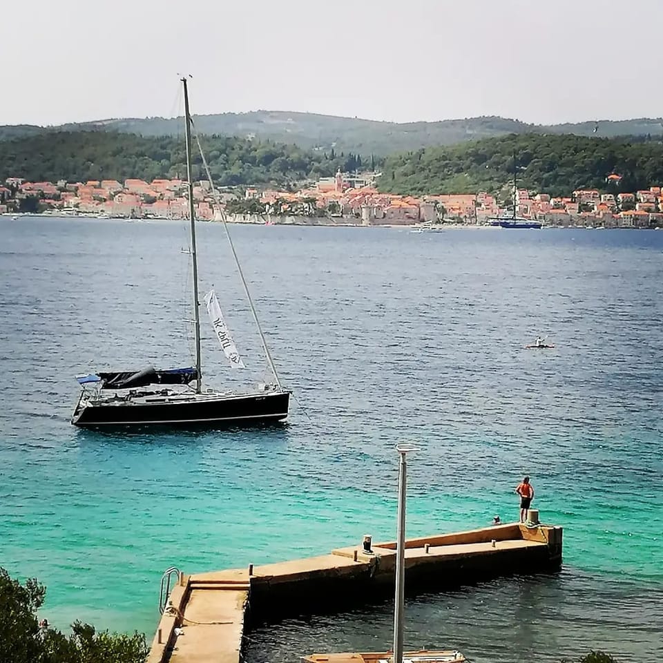 Pogled preko kanala na Korčulu s jedrilicom uz mol — Eva Apartman, Kućište