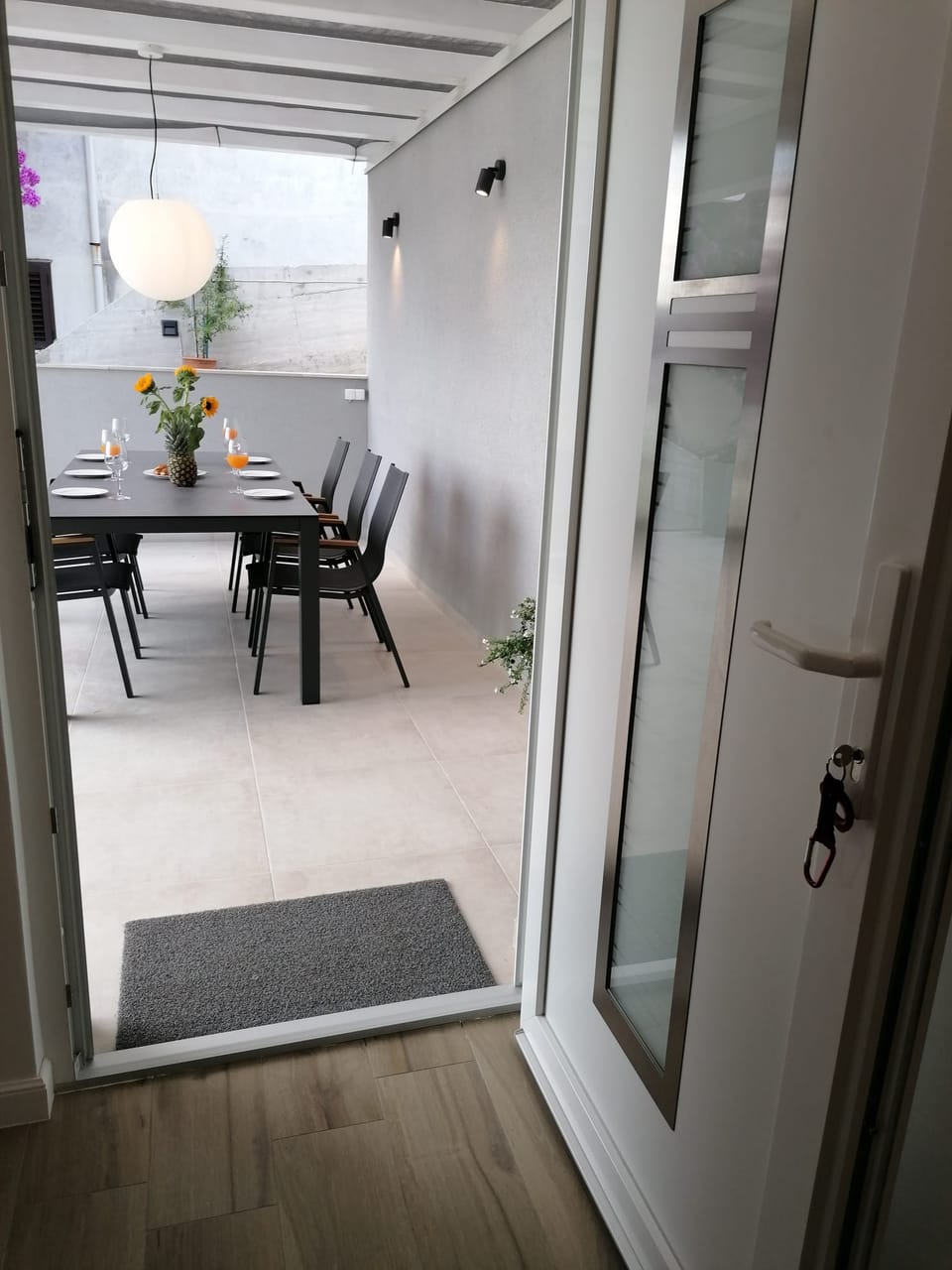 Otvorena vrata iz apartmana prema stolu na terasi — Eva Apartman, Kućište